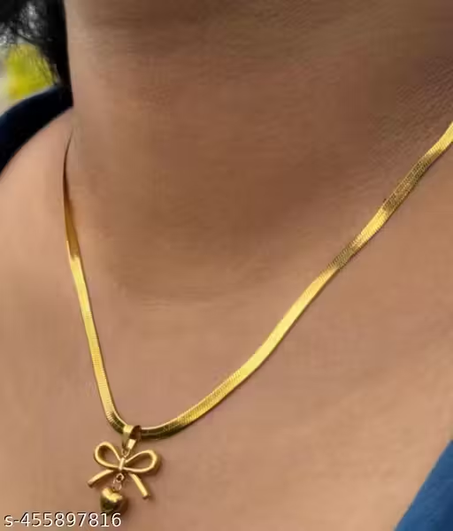 Gold-tone bow and heart pendant necklace on display bust