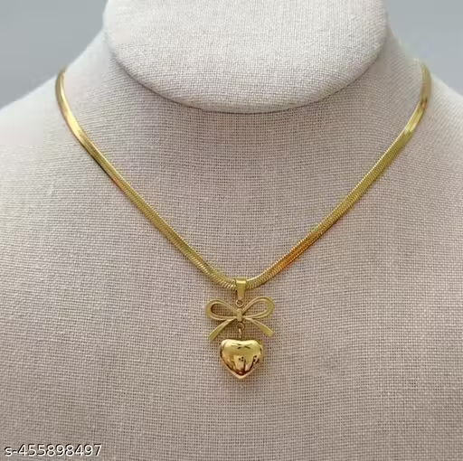 Gold-tone bow and heart pendant necklace worn close-up