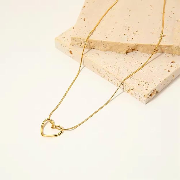 Gold-tone interlocking heart pendant necklace displayed on pedestal