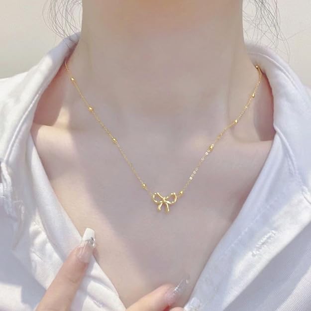 Gold-tone bow pendant necklace with ball detail chain