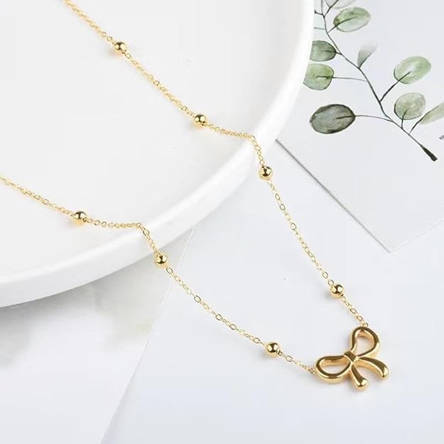 Gold-tone bow pendant necklace styled on model