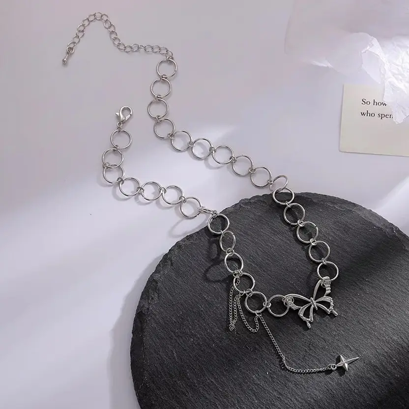 Silver-tone butterfly and star charm necklace styled on a model