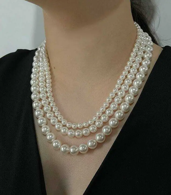 Three-layer white pearl necklace close-up on black background