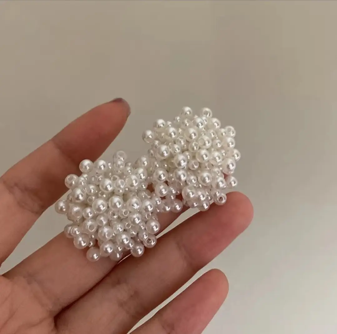 White pearl beaded stud earrings on display