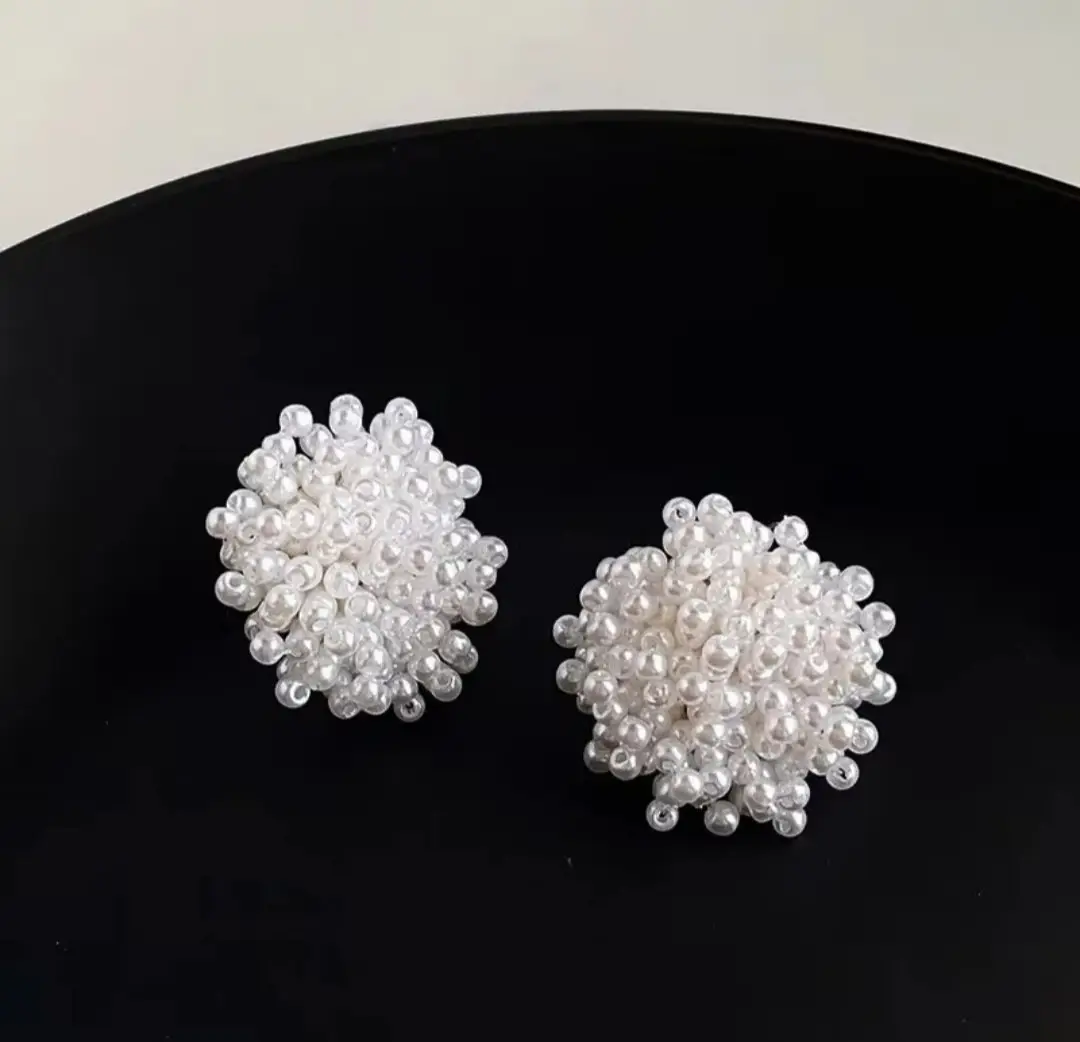 White pearl beaded stud earrings on model