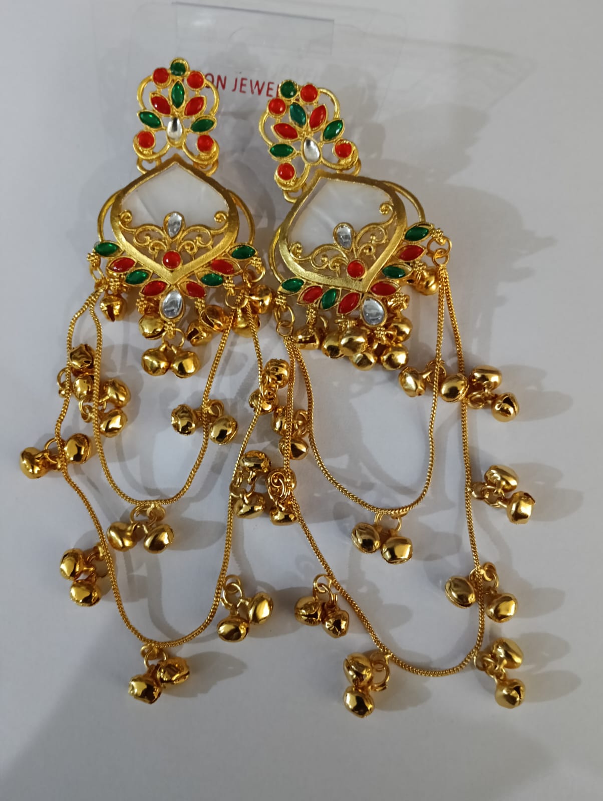 White red and green traditional long jhumka earrings in product packaging
