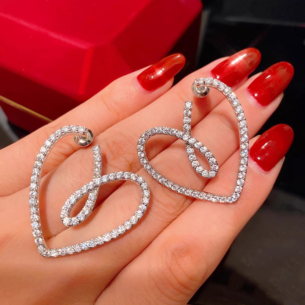 Crystal-pave heart earrings on red background