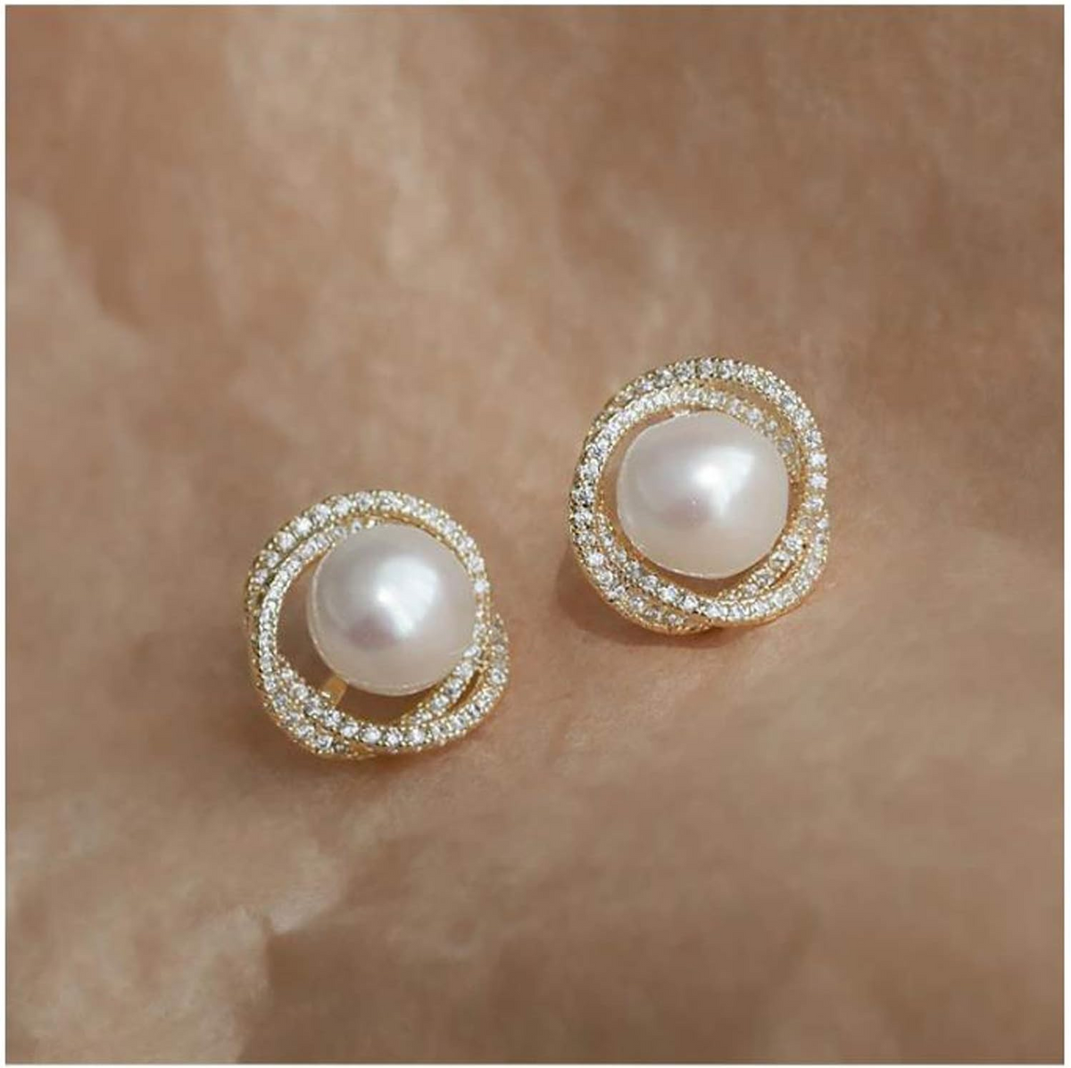 Pearl crystal stud earrings on beige background