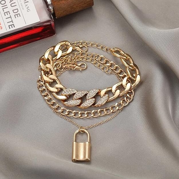 Gold-tone layered chain bracelet detail with sparkling leaf links