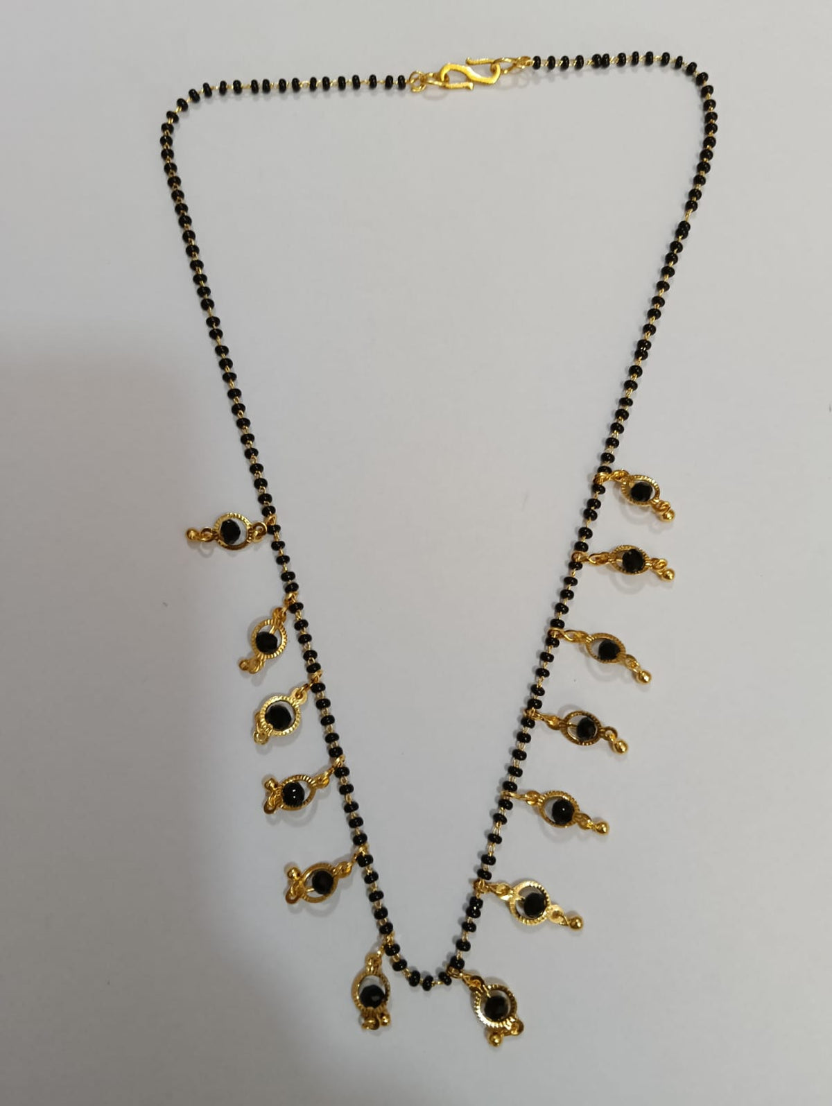 Black bead mangalsutra with gold-tone hanging charms